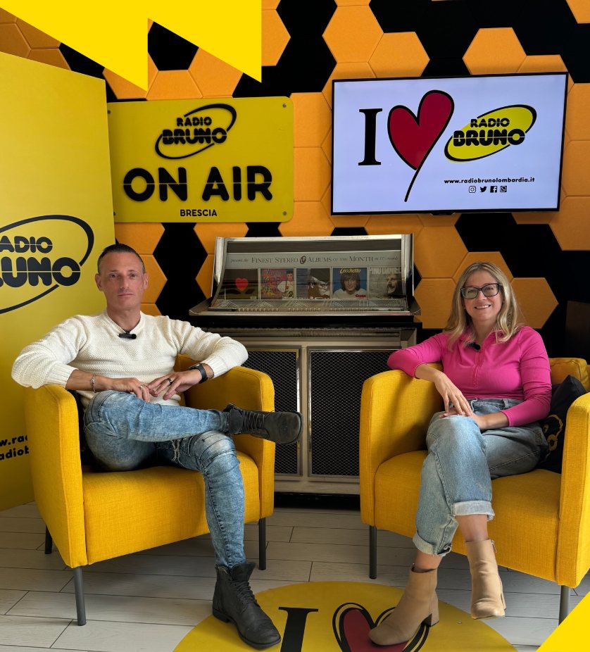 Simone Martino e Paola Ferrari seduti negli studi di Radio Bruno Brescia, sotto l'insegna ON AIR